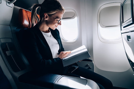 Woman reading a book on a plane