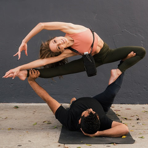 man and woman doing together a complicated yoga position