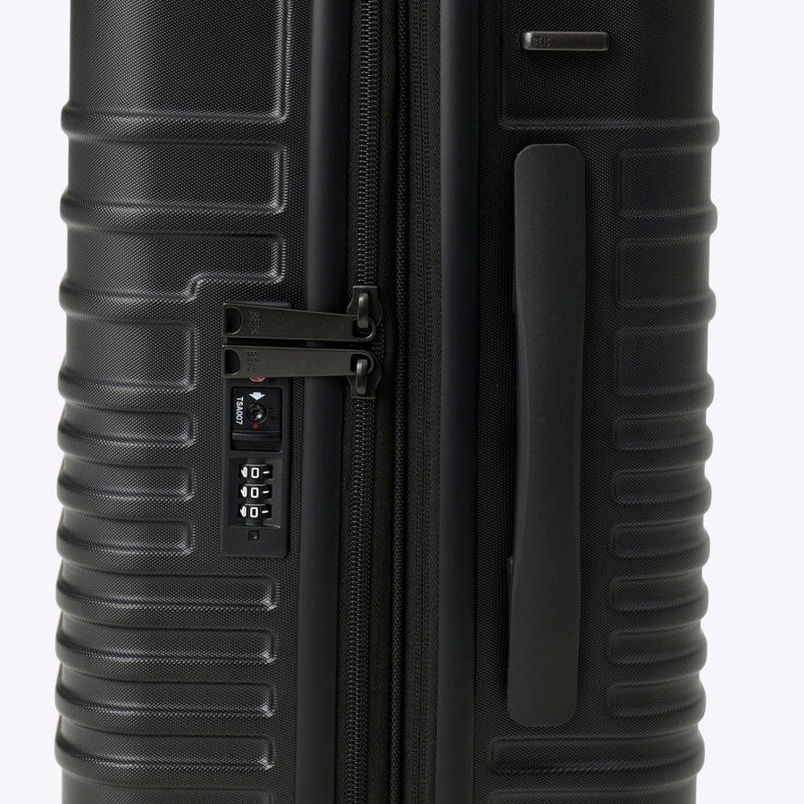 Black suitcase with a textured surface on a white background