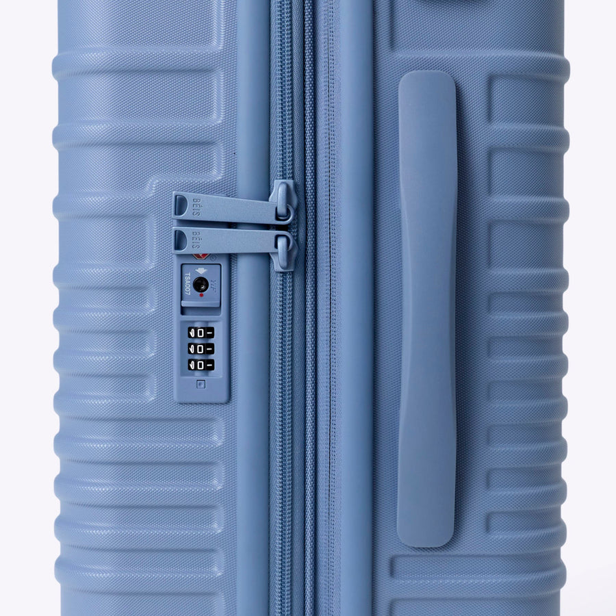 Blue suitcase with wheels on a white background
