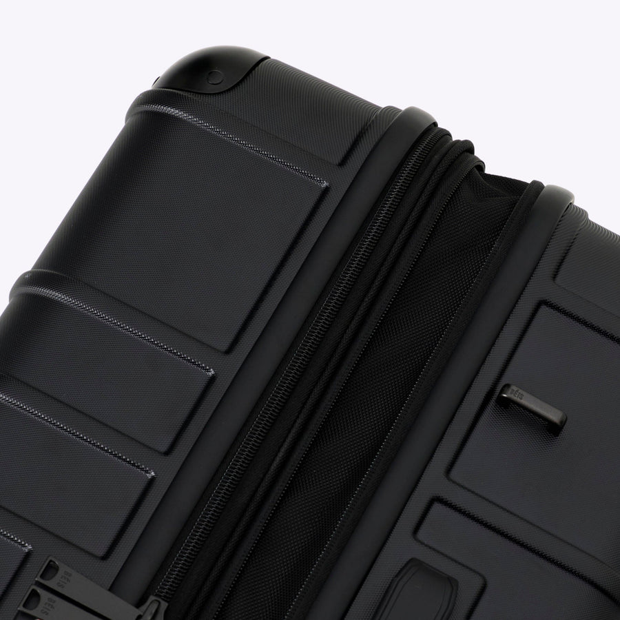 Black suitcase with textured surface on a white background