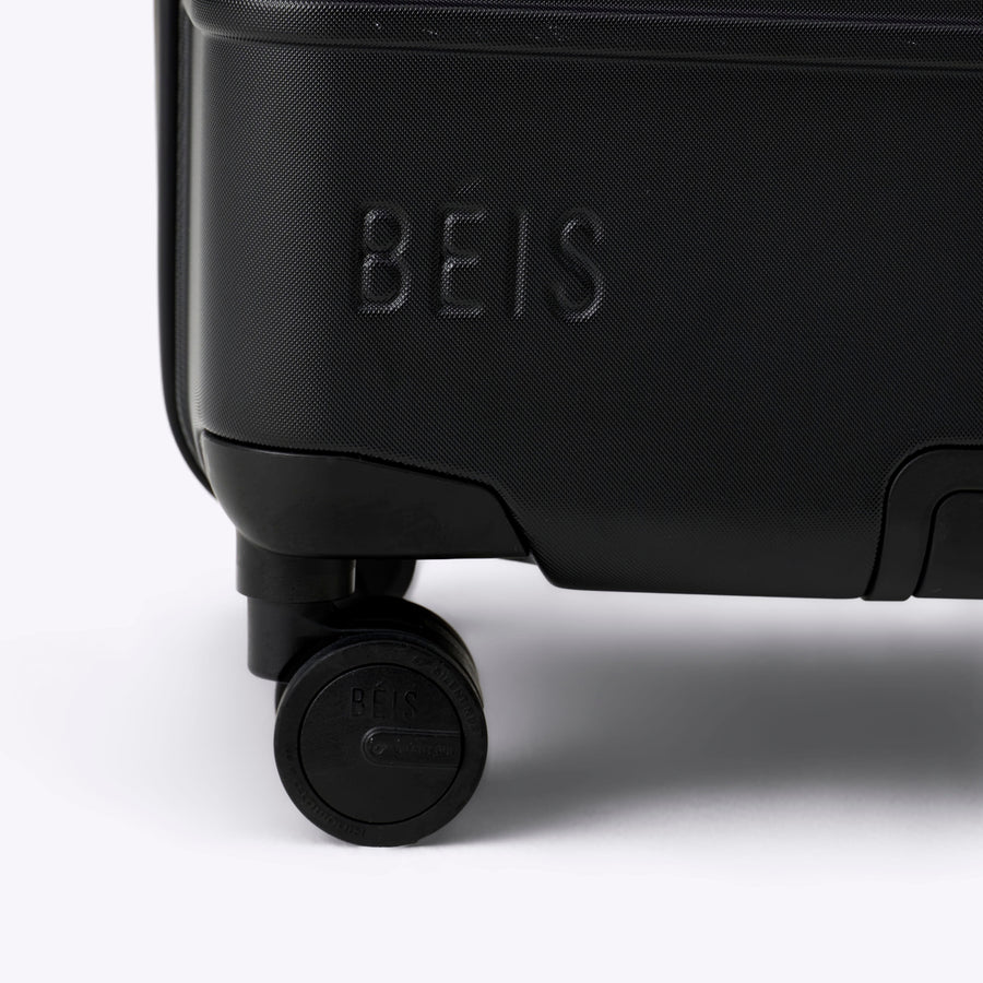 Black suitcase with 'Béis' branding on a white background