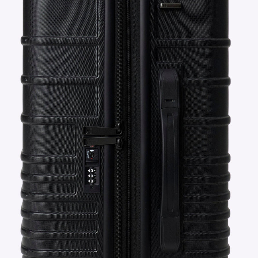 Black suitcase with wheels on a white background