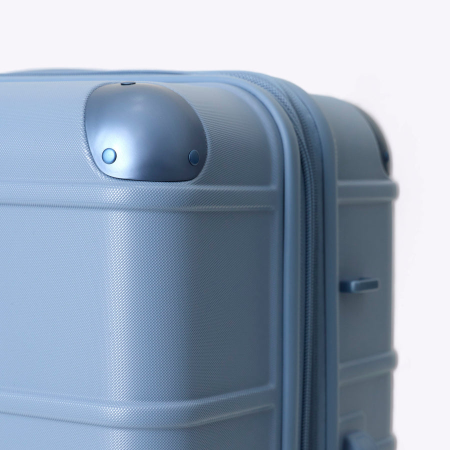 Blue suitcase with a textured surface on a light gray background